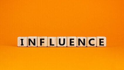 Wooden cubes with word 'influence'. Beautiful orange background. Business and educational concept. Copy space.
