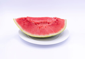 VIEW FROM THE TOP OF A QUARTER OF WATERMELON ON A WHITE PLATE