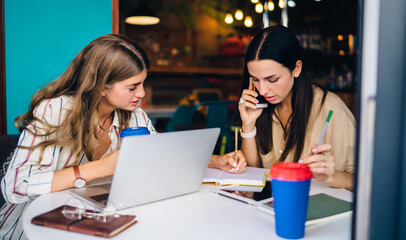 Caucasian colleagues collaborating in coffee shop using smartphone device for online consultancy...