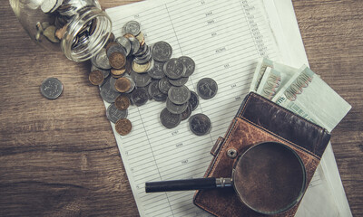 money with wallet and magnifier on document