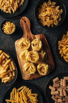 Different kind of pasta on dark background