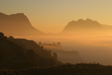 Amanecer con niebla sobre el pantano o embalse del Quípar, en Calasparra, Murcia, España. Mar de nubes y montaña.