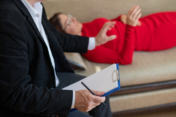 A woman lies on a couch during a psychotherapy session