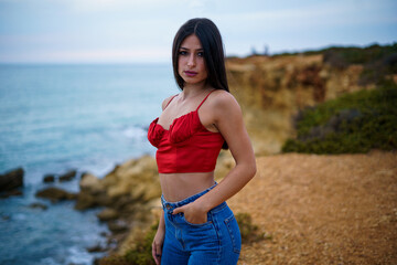 Chica caminando por ruta de playa camino de madera y vegetacion junto a un acantilado en cadiz el...