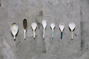 Set of craft ceramic spoons on a concrete floor