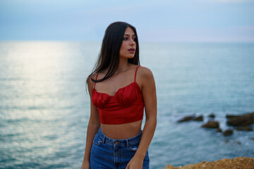 Chica caminando por ruta de playa camino de madera y vegetacion junto a un acantilado en cadiz el sur de españa

