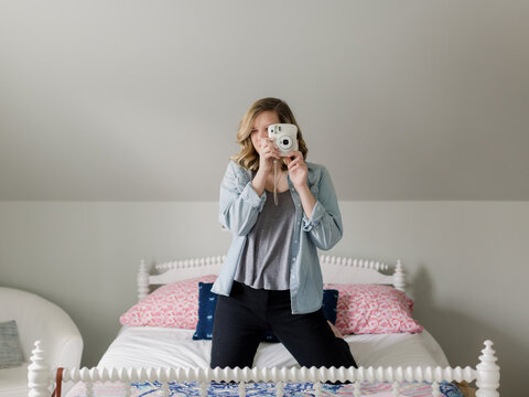 Teen girl taking pictures with an instant camera