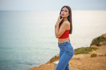 Chica caminando por ruta de playa camino de madera y vegetacion junto a un acantilado en cadiz el...