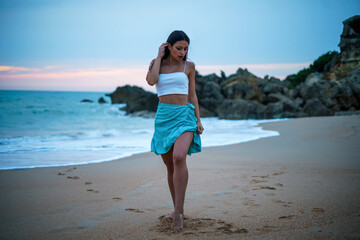 Chica caminando por la playa camino vegetacion junto a un acantilado en cadiz el sur de españa