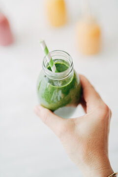 Woman holding green smoothie
