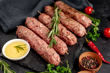 raw Lula kebab  on skewers with spices on a stone background 