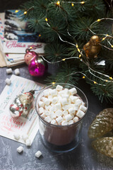 Cocoa with marshmallows on the background of vintage Christmas toys and old letters and cards.