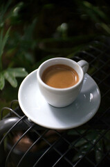 Espresso coffee in a white mug on the black table