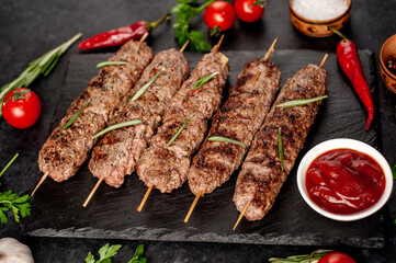 grilled Lula kebab on skewers with spices on a stone background


