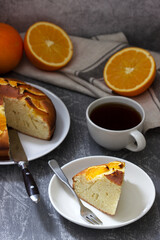 Orange cake with slices of orange on a concrete background.