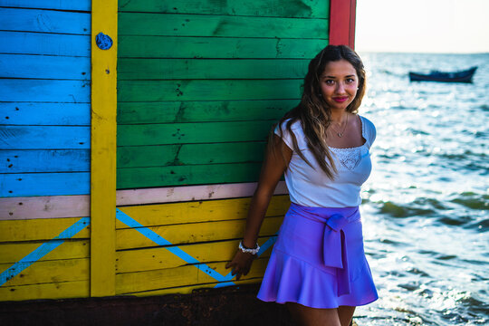 Chica joven con falda en una calle estrecha de un barrio pobre de favela en rio de janeiro brasil con muchos colores en sus casas casseria de ossio san fernando sur de españa