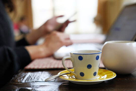 Woman using laptop computer with espresso.