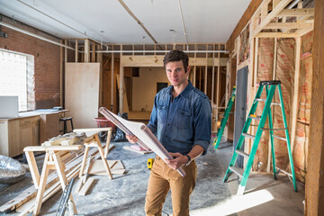 Architect reading blueprints at construction site