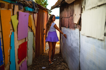 Chica joven con falda en una calle estrecha de un barrio pobre de favela en rio de janeiro brasil...