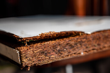 Selective focus on edge of water damaged swelled laminated plywood