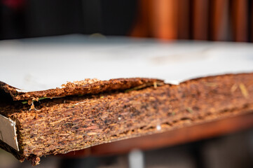 Selective focus on edge of water damaged swelled laminated plywood