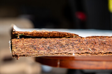 Selective focus on edge of water damaged swelled laminated plywood