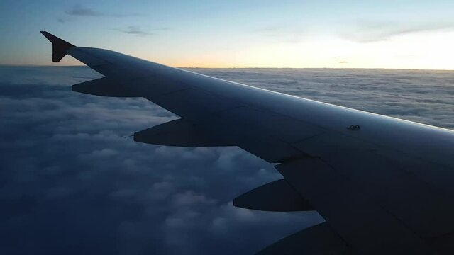 The plane is heading East. Dawn in the sky. Flying on a beautiful carpet of clouds