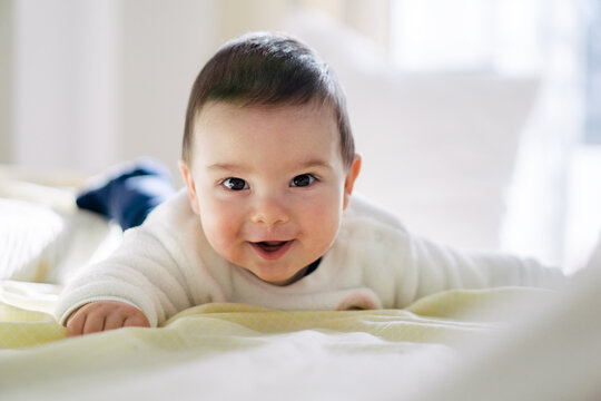 Smiling baby lying down on the bed