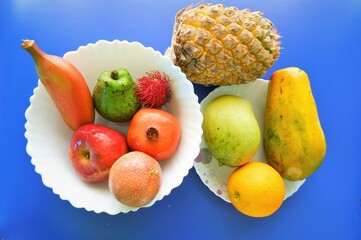 Healthy natural fruits on white plate ,top view,blue background