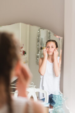 teen girl looking at her reflection in the mirror