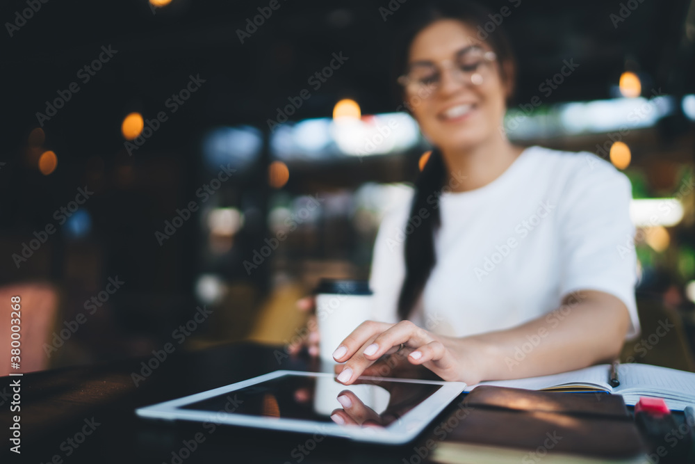 Poster selective focus on modern digital tablet lying on table, millennial woman 20s tapping and sending te