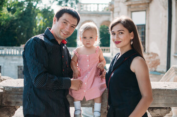 Young family with a beautiful little daughter on castle excursion