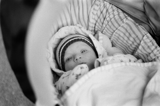 A little baby in a pram looking at camera