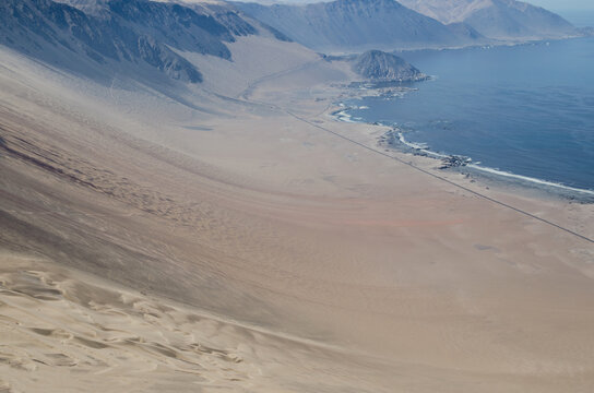 Aerial vew to colorful sands of desert, highway and ocean