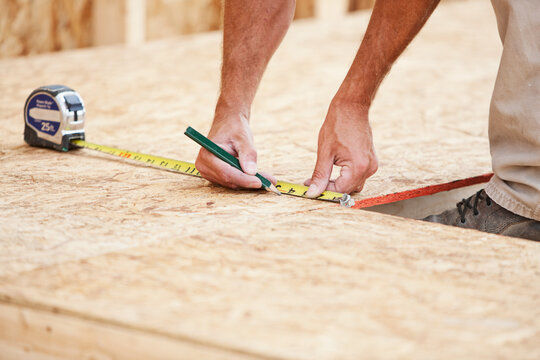 Construction: Framer Making Measurements on MDF Panel