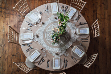 Overhead view of a dining table decorated with flowers and lace ready for a wedding party