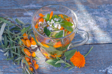 Herbal tea with lemon balm and sea buckthorn in the sun.