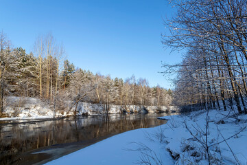 Naklejka na ściany i meble Landscape with winter forest and river. Sunrise, sunset in beautiful snowy forest.