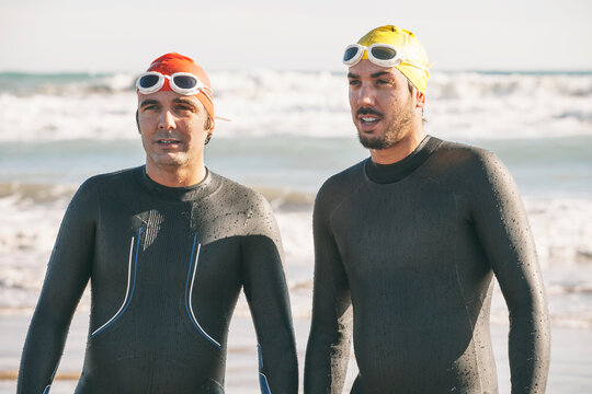 Two triathletes with wetsuit resting after triathlon race.