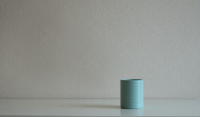 Blue can on the desk at gray wall background