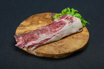 Raw beef bacon over wooden board