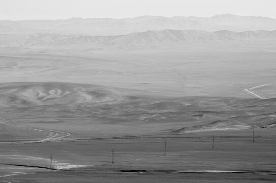 Aerial view to desert, mountains and power lines in black and wh