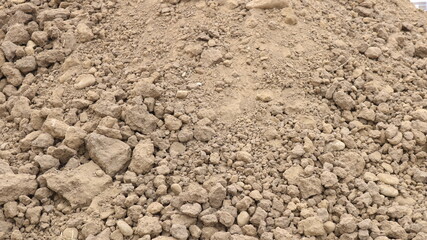 a scattered pile of dry grayish earth mixed with stones during excavation or construction work