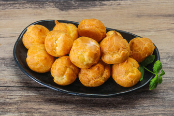 Sweet tasty profiteroles heap in the bowl