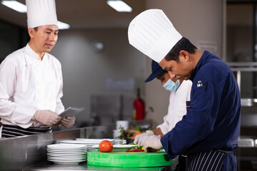 Chief of Chef audit and coaching  in kitchen , group of chef prepare and cooking food