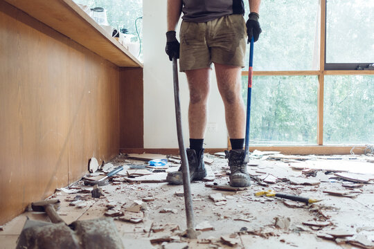 Workman pulling up Tiles on a Residential Floor