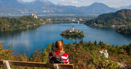 Person observing Slovenian Alpine pearl  Bled lake, with unique islands church.