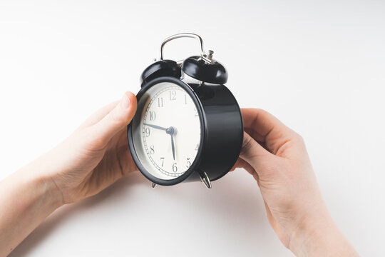 close up of a young European girl adjusting the time of the clock