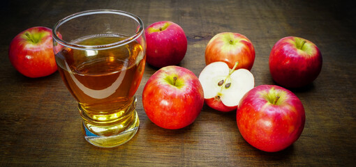 Apple cider vinegar in glass with apples on a wooden background.Selective focus.