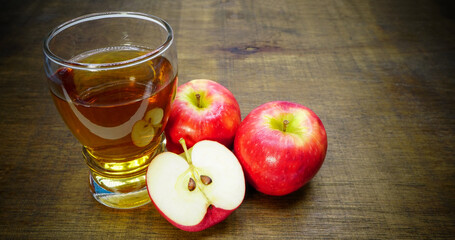 Apple cider vinegar in glass with apples on a wooden background.Selective focus.
